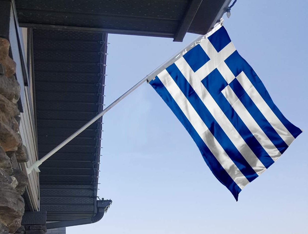 Bandera griega ondeando con el cielo azul de fondo